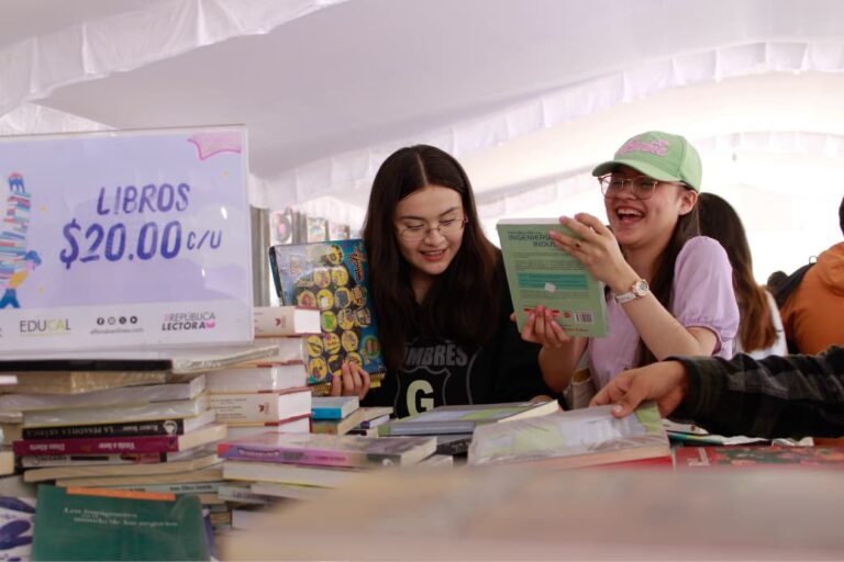 Jóvenes revisan libros durante el 22º Gran Remate de Libros, Discos y Películas en el Monumento a la Revolución